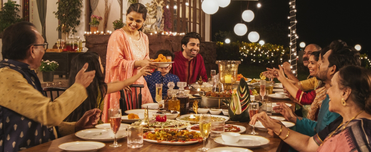 a family dines at a table together outside