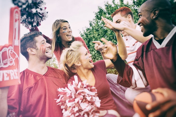 Adult football fans outside laughing