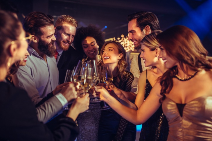 Wedding guests toast champagne glasses together