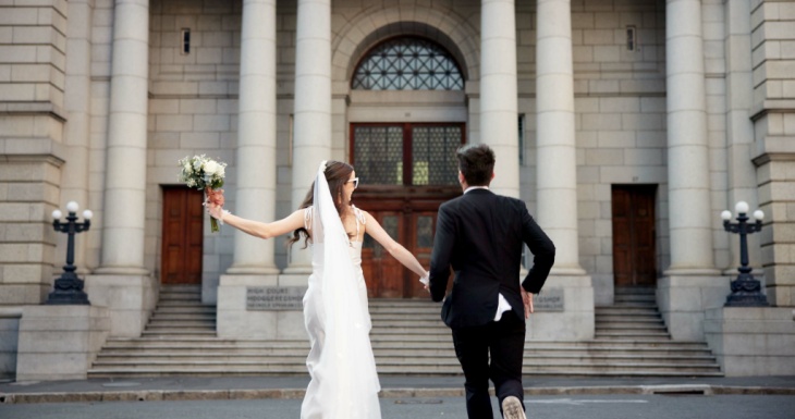 Bride and groom walking towards building