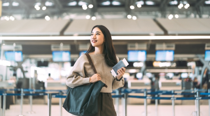 Woman in airport holding a bag