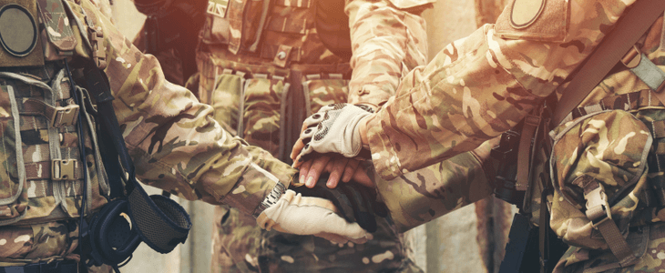 a group of military personnel put their hands together