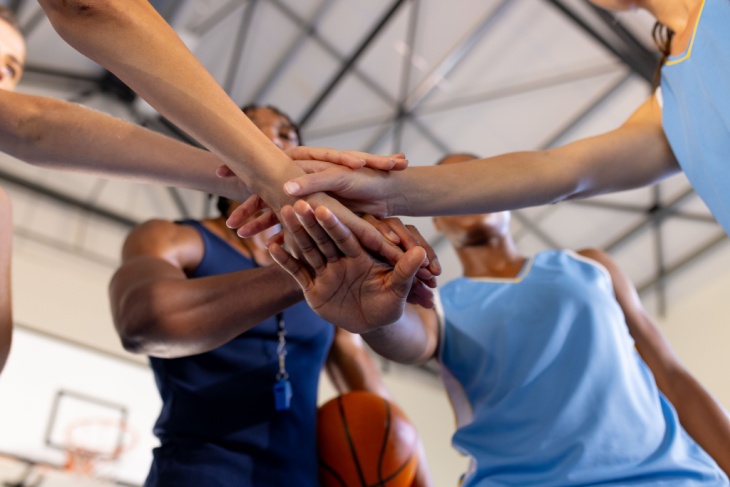 Close-up of a basketball team's hands in a circle