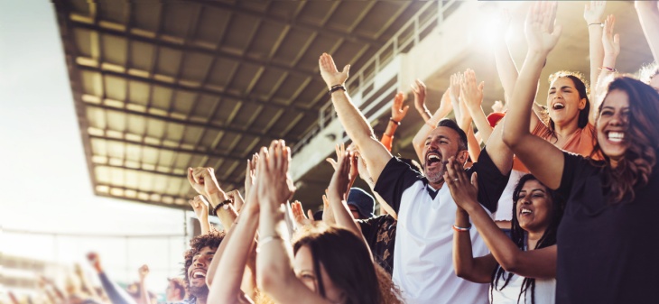 Sports fans clap and cheer for their team