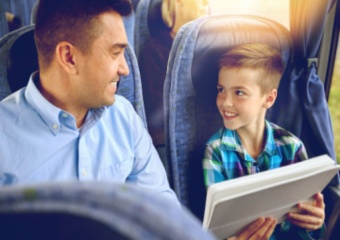 Father and son sit together on a charter bus